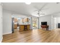 Open-concept living room featuring wood floors and seamless flow into the kitchen at 8126 Sw 105Th Pl, Ocala, FL 34481