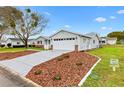 Side view of a charming single-story home with well-manicured landscaping and a concrete driveway at 9493 Se 173Rd Ln, Summerfield, FL 34491