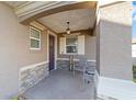 Inviting front porch with stone accents, a hanging light fixture, and a cozy seating area at 9839 Sw 99Th Loop, Ocala, FL 34481