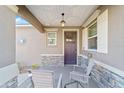 Inviting front porch with stone accents, hanging light fixture, and seating area at 9839 Sw 99Th Loop, Ocala, FL 34481