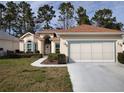 Charming single-story home with manicured lawn and a two-car garage with a brown roof at 11663 Sw 72Nd Cir, Ocala, FL 34476