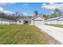 Charming single-story home boasts a manicured lawn, attached garage, and modern architectural design at 12882 Se 42Nd Ct, Belleview, FL 34420