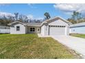 Charming single-story home boasts a manicured lawn, attached garage, and modern architectural design at 12882 Se 42Nd Ct, Belleview, FL 34420