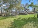 Expansive front lawn with mature trees shading a single-story home with stone accents and a welcoming ambiance at 16211 Se 62Nd Pl, Ocklawaha, FL 32179