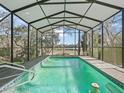 Enclosed swimming pool featuring an airy metal frame enclosure, providing a serene and private outdoor retreat at 16211 Se 62Nd Pl, Ocklawaha, FL 32179