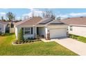 Inviting single-story home featuring lush landscaping, a two-car garage, and stone accents for added character at 5370 Sw 45Th Ave, Ocala, FL 34474