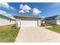 Picture of a two-car garage featuring a concrete driveway and well-maintained landscaping at 6213 Sw 97Th St, Ocala, FL 34476