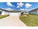 Exterior shot showcasing a two-car garage with a concrete driveway and landscaped front yard at 6213 Sw 97Th St, Ocala, FL 34476