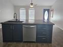 Kitchen island with dark cabinetry, stainless steel dishwasher, and a modern faucet at 6699 Nw 61St St, Ocala, FL 34482