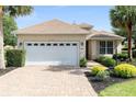 Charming single-Gathering home featuring a two-car garage, mature landscaping, and a well-maintained lawn at 8669 Sw 88Th Loop, Ocala, FL 34481