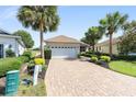 Charming single-Gathering home featuring a two-car garage, brick paver driveway, and mature landscaping at 8669 Sw 88Th Loop, Ocala, FL 34481