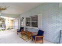 Charming front porch with seating, lovely plants, and blue brick siding at 8677 Sw 95Th Ln # E, Ocala, FL 34481