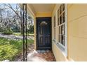 Welcoming black front door with decorative window and 'WELCOME' mat on the charming tiled porch at 903 Ne 2Nd St, Ocala, FL 34470