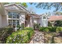 Charming home with large windows, lush landscaping and a brick walkway at 11587 Sw 72Nd Cir, Ocala, FL 34476
