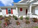 Close-up of the front entrance showcasing the red window shutters and lush landscaping at 13042 Sw 60Th Court Rd, Ocala, FL 34473