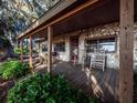 Inviting covered porch with stone accents, rocking chairs, and outdoor seating; ideal for relaxation and entertainment at 14540 Ne 250Th Ave, Fort Mc Coy, FL 32134