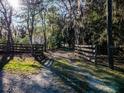 Scenic driveway framed by wooden fences and mature trees draped in moss creates a private, natural entrance at 14540 Ne 250Th Ave, Fort Mc Coy, FL 32134