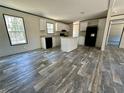 Open-concept kitchen with white cabinets, an island, and sleek black appliances offers modern style at 1921 Nw 120Th Ave, Ocala, FL 34482