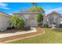 Elegant front entrance featuring double doors, an arched entryway, and manicured landscaping at 1956 Nw 50Th Cir, Ocala, FL 34482