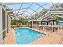 A screened-in pool with seating areas and well-maintained tile flooring at 20280 Sw 69Th Pl, Dunnellon, FL 34431