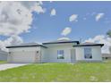 New construction, single-story home featuring a two-car garage door, stone accents, and a freshly cut lawn at 2602 Sw 154Th Ln, Ocala, FL 34473
