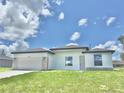 New construction, single-story home featuring a two-car garage door, stone accents, and a freshly cut lawn at 2602 Sw 154Th Ln, Ocala, FL 34473