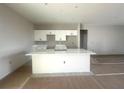 Bright kitchen featuring an island with quartz countertop and white cabinets at 2602 Sw 154Th Ln, Ocala, FL 34473