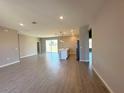 Open-concept living space with wood-look tile flooring and a kitchen island in the background at 2602 Sw 154Th Ln, Ocala, FL 34473