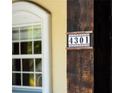 Close up of address number '4301' on a wooden beam next to a window at 4301 Se 6 Ave, Ocala, FL 34480