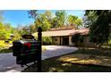 Street view of a single-story home with a charming mailbox at the curb and circular driveway at 4301 Se 6 Ave, Ocala, FL 34480