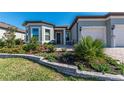 Inviting home showcasing lovely landscaping and a cozy front patio with chairs at 8843 Sw 57Th Place Rd, Ocala, FL 34481