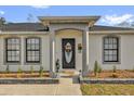 Close-up of the front door with decorative details and neat landscaping around the entrance at 1 Hemlock Terrace Trak, Ocala, FL 34472