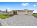 Charming single-story home featuring a three-car garage and a patterned brick driveway at 10314 Sw 96Th Loop, Ocala, FL 34481