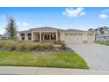 Attractive home featuring a three-car garage, neutral color palette, and beautiful landscaping at 10314 Sw 96Th Loop, Ocala, FL 34481