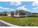 Lawn view showcasing the side of this beautifully landscaped single-story home with its freshly cut lawn at 10557 Sw 98Th Ln, Ocala, FL 34481
