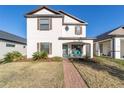 Charming two-story home with a landscaped front yard and welcoming brick pathway at 10597 Grand Oaks Blvd, Oxford, FL 34484