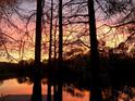 Beautiful sunset reflecting on the lake, visible from the property at 11720 Cherokee Cir, Dunnellon, FL 34431
