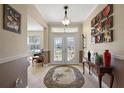 Elegant foyer with tile flooring, a decorative rug, and glass double doors leading to the outside at 12133 Se 91St Ter, Summerfield, FL 34491