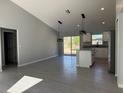 Bright living space with vaulted ceilings and gray tile flooring leading into an open kitchen at 12199 Se 88Th Ct, Belleview, FL 34420