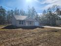 Exterior shot shows home with a neutral stucco exterior and a well-manicured lawn surrounded by tall trees at 127 Sw Alvarez Rd, Dunnellon, FL 34431