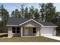 Charming single-story home boasts a well-maintained lawn, a concrete driveway, and a neutral-colored stucco exterior at 127 Sw Alvarez Rd, Dunnellon, FL 34431