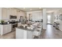 Bright kitchen with white cabinets, stainless steel appliances, a granite island, and seating for three at 4266 Sw 53Rd Lane Rd, Ocala, FL 34474