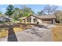 Inviting home showcasing a stone accent wall, attached garage, and well-maintained driveway at 4425 Se 2Nd Pl, Ocala, FL 34471