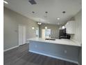 Open-concept kitchen with white cabinets, pendant lighting, and a breakfast bar at 6620 Se 108Th Ln, Belleview, FL 34420