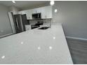 Close-up view of a kitchen with a white quartz countertop and stainless steel appliances at 6620 Se 108Th Ln, Belleview, FL 34420