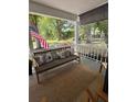 Relaxing front porch with a cozy bench, decorative pillows, outdoor rug, and a view of the landscaped yard at 8665 Sw 94Th Ln # C, Ocala, FL 34481