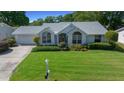 Well-maintained single-story home with a green lawn and tidy landscaping at 8832 Sw 108Th St, Ocala, FL 34481