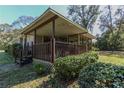 Inviting covered porch featuring a grill and a partial view of screened porch at 9108 Sw 197Th Cir, Dunnellon, FL 34432