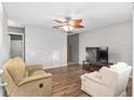 Cozy living room with hardwood floors, ceiling fan, and comfortable seating at 10495 Sw 100Th Ave, Ocala, FL 34481