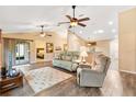 Open-concept living room with wood floors, comfortable seating, and seamless access to the adjacent kitchen at 11013 Se 169Th Pl, Summerfield, FL 34491